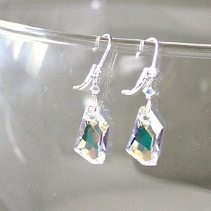 May include: A pair of silver dangle earrings with iridescent crystal drops. The crystals are faceted and have a green hue.