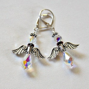May include: Silver angel wing earrings with iridescent crystal drops and a red accent bead.