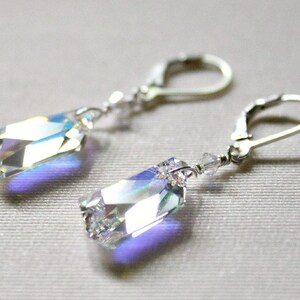 May include: A pair of silver earrings with iridescent crystal teardrop-shaped pendants.