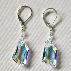 May include: A pair of silver earrings with iridescent crystal drops. The crystals are faceted and have a rainbow effect. The earrings have lever back closures.