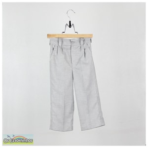 May include: Light gray dress pants hanging on a wooden hanger. The pants have a button closure and pleats at the waist. The pants are made of a textured fabric and have pockets. The pants are displayed against a white background.
