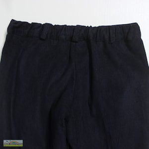 K&ouml;nnte beinhalten: Nahaufnahme einer marineblauen Hose mit elastischem Bund. Die Hose hat ein schlichtes, klassisches Design, das f&uuml;r verschiedene Anl&auml;sse geeignet ist. Der Stoff scheint ein mittelschweres Material mit einer dezenten Textur zu sein. Der Fokus liegt auf dem Bund und dem oberen Teil der Hose.