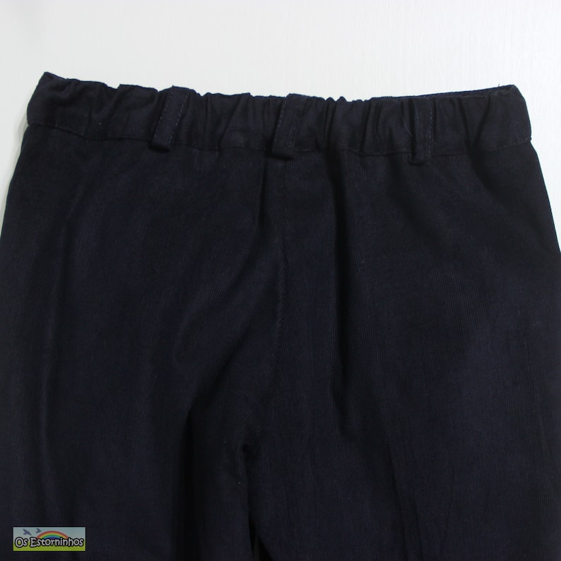 K&ouml;nnte beinhalten: Nahaufnahme einer marineblauen Hose mit elastischem Bund. Die Hose hat ein schlichtes, klassisches Design, das f&uuml;r verschiedene Anl&auml;sse geeignet ist. Der Stoff scheint ein mittelschweres Material mit einer dezenten Textur zu sein. Der Fokus liegt auf dem Bund und dem oberen Teil der Hose.