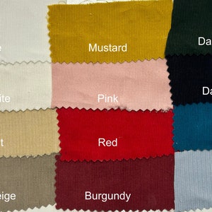 May include: A collection of fabric swatches in various colors, including white, off-white, wheat, burnt beige, mustard, pink, red, burgundy, dark green, dark blue, teal, and blue. Each swatch has a textured corduroy appearance with the color name displayed.
