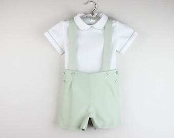 Conjunto de pantalones cortos para niño: camisa blanca con cuello Peter Pan, pantalones cortos con ribete y tirantes a juego.