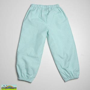 May include: Light blue and white gingham patterned pants with elastic waist and cuffs. The pants are made of a lightweight fabric, perfect for casual wear. The pants are laid flat on a white surface.