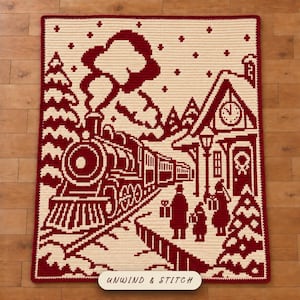 May include: A rectangular crochet blanket featuring a two-tone dark red and cream design of a steam train arriving at a station. The scene includes a clock tower, pine trees, falling snow, and figures holding gifts. The text UNWIND & STITCH is visible.