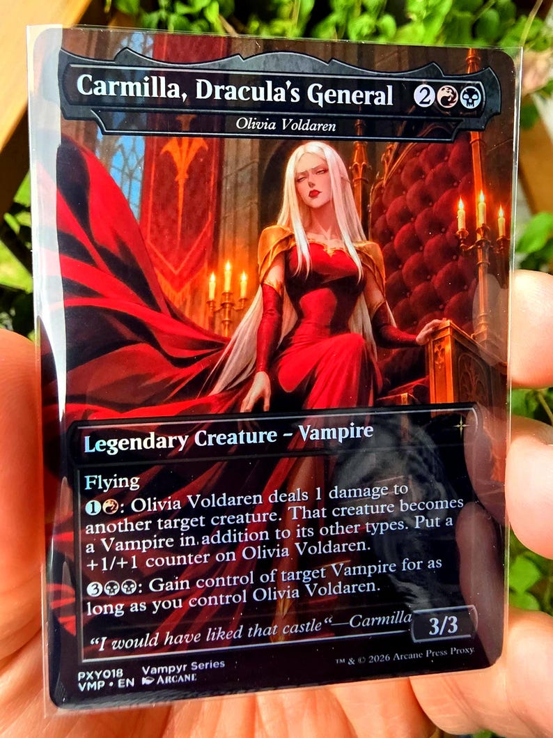 May include: A collectible trading card titled Carmilla, Dracula's General, featuring an illustration of a long-haired figure in a red dress sitting on a throne. The card text includes Legendary Creature - Vampire, Flying, and game rules, with a 3/3 power and toughness rating at the bottom right.