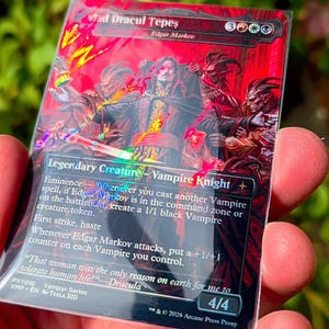 May include: A rectangular trading card featuring a red and black illustration of a vampire knight titled Vlad Dracul Tepes. The card displays game text, a 4/4 power and toughness rating, and the text 2026 Arcane Press Proxy at the bottom.