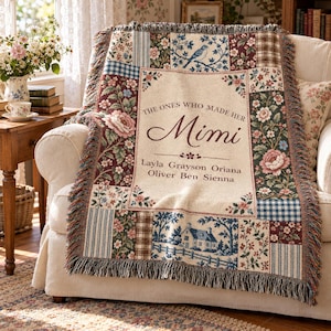 May include: A woven throw blanket featuring a patchwork design with floral patterns, plaid squares, a bird on a branch, and a house. The center panel is cream-colored with the text "THE ONES WHO MADE HER Mimi" followed by the names Layla, Grayson, Oriana, Oliver, Ben, and Sienna.
