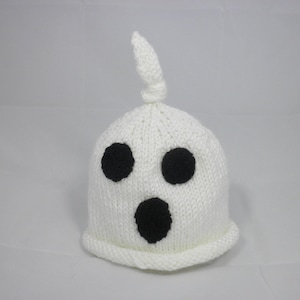 Puede incluir: Un gorro de fantasma blanco tejido con tres rasgos faciales negros: dos ojos redondos y una boca ovalada grande. El gorro tiene una parte superior anudada y un borde acanalado. Este gorro con tem&aacute;tica de Halloween es perfecto para disfraces.