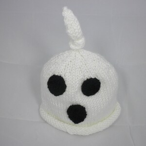 Puede incluir: Un gorro de fantasma blanco tejido con tres agujeros negros para los ojos y una boca negra. El gorro tiene una parte superior anudada y un borde enrollado. Este gorro hecho a mano es perfecto para Halloween o fiestas de disfraces.