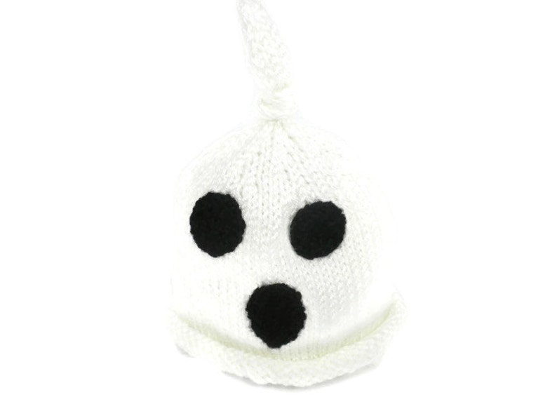 Puede incluir: Un gorro de fantasma blanco tejido con tres detalles circulares negros para los ojos y la boca. El gorro tiene forma redondeada con una parte superior anudada. El gorro est&aacute; dise&ntilde;ado para beb&eacute;s y ni&ntilde;os.