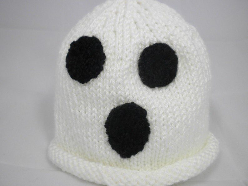 Puede incluir: Un gorro blanco tejido con tres detalles circulares negros, que se asemejan a un fantasma. El gorro tiene un borde doblado y est&aacute; hecho de un hilo suave y texturizado. Este gorro hecho a mano es ideal para Halloween o fiestas de disfraces.