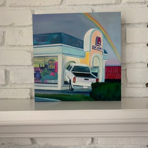 May include: A painting of a Taco Bell restaurant with a rainbow in the sky. A white pickup truck is parked in the drive-thru lane with the words "Drive Thru Open" on the window.