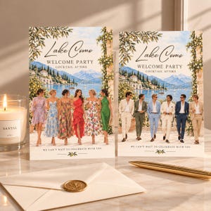 Könnte beinhalten: Zwei rechteckige Einladungskarten mit einer Landschaftsillustration vom Comer See mit Olivenzweigen, dem Text Lake Como Welcome Party Cocktail Attire und We Can't Wait To Celebrate With You, neben einer Kerze und einem goldenen Stift.