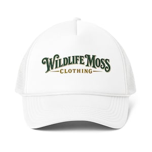 May include: A white trucker cap featuring a mesh back and a structured front panel. The front displays the text Wildlife Moss Clothing in a dark green serif font with a gold outline, centred above a horizontal gold line.