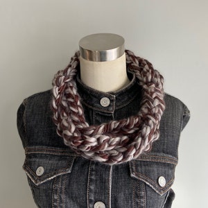 This chunky brown and gray scarf necklace is made of many layers of crochet chains by designer DottieQ. Each chain is secured with a signature knot, which is wrapped around a 2-3 inch area  with a crochet detail up the middle.