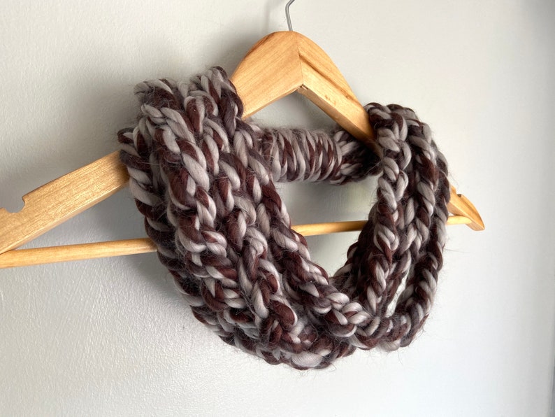 This chunky brown and gray scarf necklace is made of many layers of crochet chains by designer DottieQ. Wear it gathered and sleek like an infinity scarf, or twisted for a layered chain look.