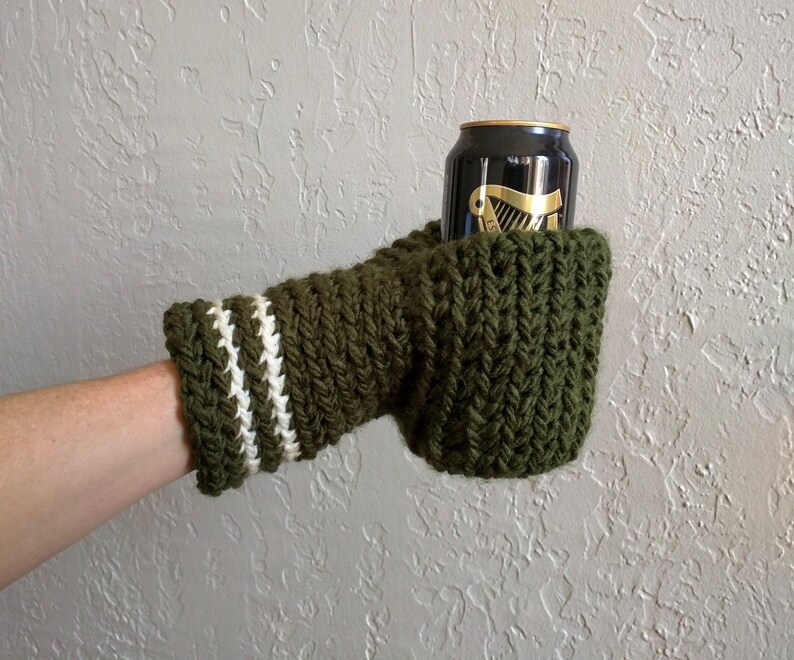 This beer mitten is green with white stripes around the wrist. It is part crochet can holder part mitten. A hand is in it and a can of beer inside the holder. The bottom is covered so the can stays in place. It can be used on either hand.