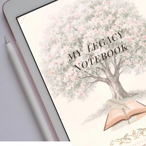 Puede incluir: Una tableta digital que muestra una pantalla con una ilustración en acuarela de un árbol grande con flores rosas. Debajo del árbol hay un libro abierto con una pluma sobre sus páginas. El texto MY LEGACY NOTEBOOK está impreso en mayúsculas negras.