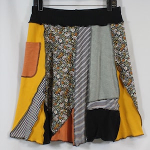 Saia de patchwork feita com tecido reciclado na altura do joelho, com bolso, nas cores preto e amarelo mesclado, tamanho M (8-12).