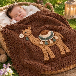 May include: A dark brown crocheted baby blanket featuring a tan camel appliqué with a decorative saddle, teal and cream tassels, and a scalloped border. The blanket is draped over a sleeping infant in a woven basket with a teddy bear.