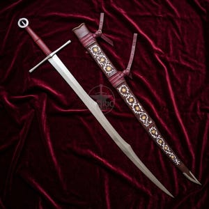 May include: A longsword with a circular pommel, a straight crossguard, and a leather-wrapped grip. Beside it lies a matching dark red leather scabbard featuring intricate white vine embroidery and gold-coloured sun-shaped accents.