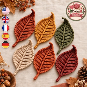 May include: Six crocheted leaf appliques in autumn colors including rust, mustard yellow, olive green, beige, orange, and deep red. Each leaf features a central raised rib and textured stitch pattern. The logo AB Crochet Hub is visible.