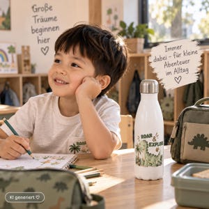Könnte beinhalten: Eine weiße Edelstahl-Trinkflasche mit silbernem Verschluss, verziert mit einer grünen Dinosaurier-Illustration und dem Text ROAR & EXPLORE. Die Flasche ist mit Palmen und kleinen Pflanzen bedruckt und steht aufrecht auf einer Holzoberfläche.