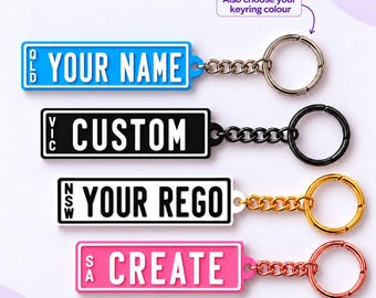May include: Four rectangular keychains resembling number plates with metal chains and rings. The top is blue with white text QLD YOUR NAME, second is black with white text VIC CUSTOM, third is white with black text NSW YOUR REGO, and bottom is pink with white text SA CREATE.