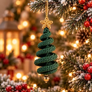 May include: A dark green crocheted Christmas tree ornament featuring a spiral design. The ornament is topped with a small, textured gold crocheted star and hangs from a gold cord. A single, smooth, reflective gold bead is attached to the bottom tip.