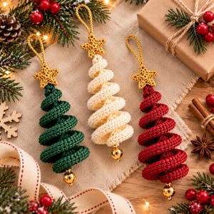 May include: Three spiral-shaped Christmas tree ornaments made of crocheted yarn in dark green, cream, and deep red. Each ornament features a gold crocheted star at the top and a small, shiny gold-toned spherical bell attached to the bottom point.