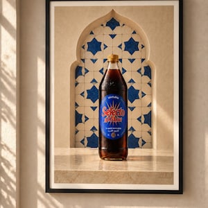 May include: A 1-liter bottle of dark brown Selecto soda with a blue circular label featuring red text and a sunburst design. The bottle has a gold cap and is positioned in front of a decorative archway with blue and white star-patterned tiles.