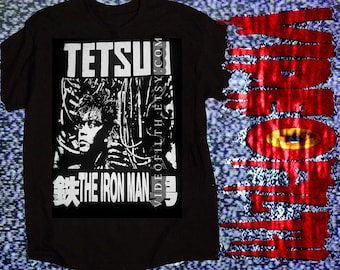 May include: A black t-shirt featuring a white graphic print of a person surrounded by wires with the text TETSUO THE IRON MAN and VIDEOFILTH.ETSY.COM. To the right, a vertical red graphic with a yellow eye design and dripping paint effects.