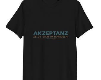 Könnte beinhalten: Ein schwarzes T-Shirt mit kurzen Ärmeln, das auf der Brust den Text AKZEPTANZ ZEIGT SICH IM HANDELN. in blauer und beiger Schrift trägt, ergänzt durch den kleineren, darunter zentrierten Schriftzug autismuskompakt.