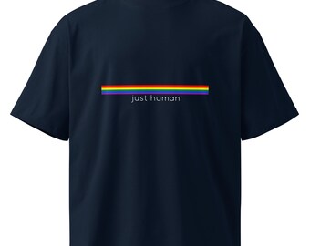 Könnte beinhalten: Ein dunkelblaues T-Shirt mit kurzen Ärmeln und einem horizontalen Regenbogenstreifen auf der Brust. Unter dem Regenbogenstreifen ist der Text "just human" in einer einfachen, klaren, weißen serifenlosen Schrift auf der Vorderseite gedruckt.