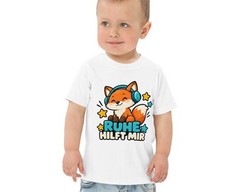 Könnte beinhalten: Ein weißes T-Shirt mit kurzen Ärmeln und einer Grafik eines orangefarbenen Fuchses mit blauen Kopfhörern. Der Fuchs ist von kleinen gelben und blauen Sternen umgeben. Unter dem Fuchs steht der Text RUHE HILFT MIR in blauer und schwarzer Schrift.