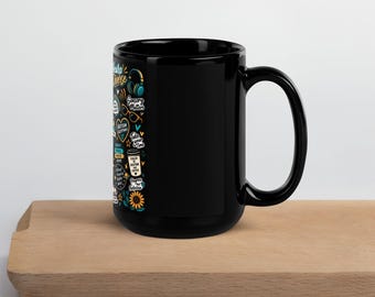 Könnte beinhalten: Ein schwarzer Keramikbecher mit einem farbenfrohen Grafikdesign auf der Seite. Der Aufdruck enthält verschiedene Symbole und Texte wie "Neuro Diverse", "Sensory Matters", "Autism Acceptance", "Take Your Time" und "Fueled by Routine and Coffee".