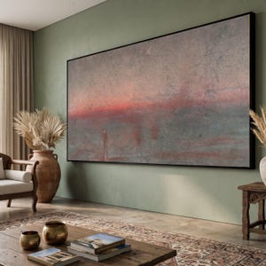 May include: A large rectangular wall art piece featuring an abstract landscape with a textured surface. The painting displays a horizontal gradient of muted gray, blue, and soft pink tones, framed in a thin black border, creating a serene visual.
