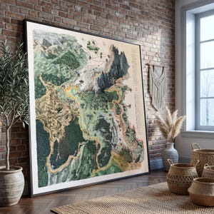 May include: A large framed wall art print featuring a detailed fantasy map with green forests, tan plains, and dark gray mountain ranges. The map includes winding paths, small illustrations of structures, and a vertical legend on the right side.