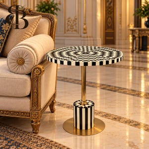 May include: A round side table featuring a black and white checkered pattern on the top surface, a gold-toned metal central support column, and a cylindrical base with vertical black and white stripes resting on a circular gold-toned metal plate.