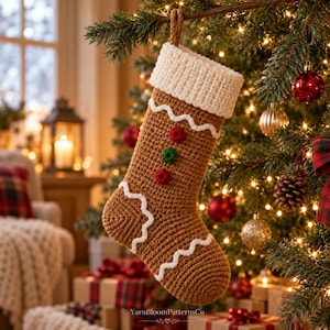 Pode incluir: Uma meia de Natal de crochê marrom com punho canelado branco, acabamento ondulado branco e três pequenos detalhes circulares em vermelho e verde. A meia tem uma alça de suspensão marrom e inclui o texto YarnBloomPatternsCo na parte inferior.