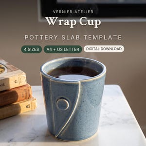 May include: A blue ceramic cup with a speckled finish and a raised triangular wrap design featuring a circular accent. Text reads: VERNIER ATELIER Wrap Cup POTTERY SLAB TEMPLATE 4 SIZES A4 + US LETTER DIGITAL DOWNLOAD.