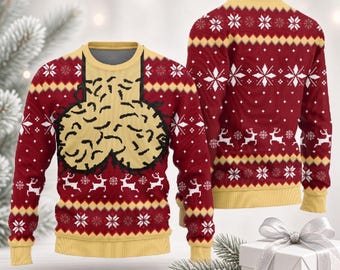 Può includere: Un maglione a maniche lunghe con girocollo in rosso scuro e giallo con un motivo festivo di fiocchi di neve e renne bianche. La parte anteriore presenta una grande grafica centrale di due forme arrotondate e testurizzate in giallo.