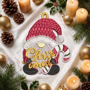 May include: An embroidered patch featuring a gnome wearing a textured red hat and white trim, holding a gold-stitched 'Christmas' sign and a red and white striped candy cane, with black gloves and boots, designed for holiday decoration.