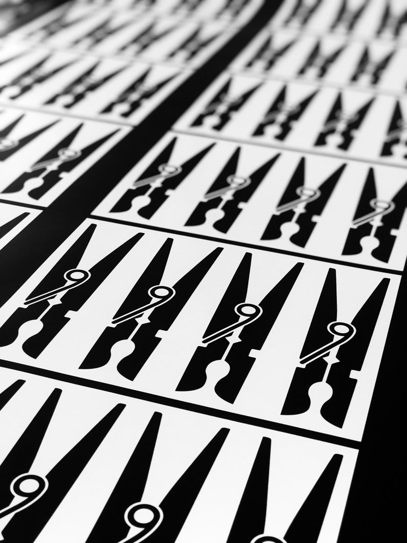 May include: A repeating pattern of black and white clothespin illustrations. The clothespins are arranged in rows and columns on a white background, with a black border separating the rows. The design is simple and graphic.