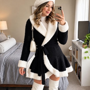 May include: A black crochet wrap coat featuring a white faux-shearling trim along the collar, cuffs, and hem. The coat includes a matching black tie belt at the waist, a flared skirt silhouette, and long sleeves. A small white shoulder bag is worn.