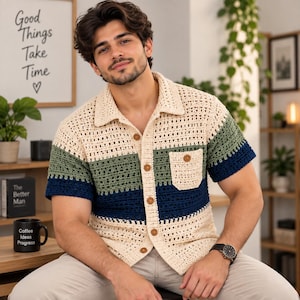 Peut inclure: Une chemise à manches courtes en crochet avec un design à blocs de couleurs composé de rayures horizontales crème, vert sauge et bleu marine. La chemise présente un col classique, une poche poitrine unique et des boutons marron sur le devant.