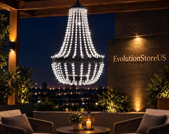 May include: A hanging chandelier featuring a black metal frame adorned with numerous clear, faceted glass beads arranged in a tiered, bell-shaped structure. The fixture emits a bright, sparkling light, suspended from a dark chain against a night sky.